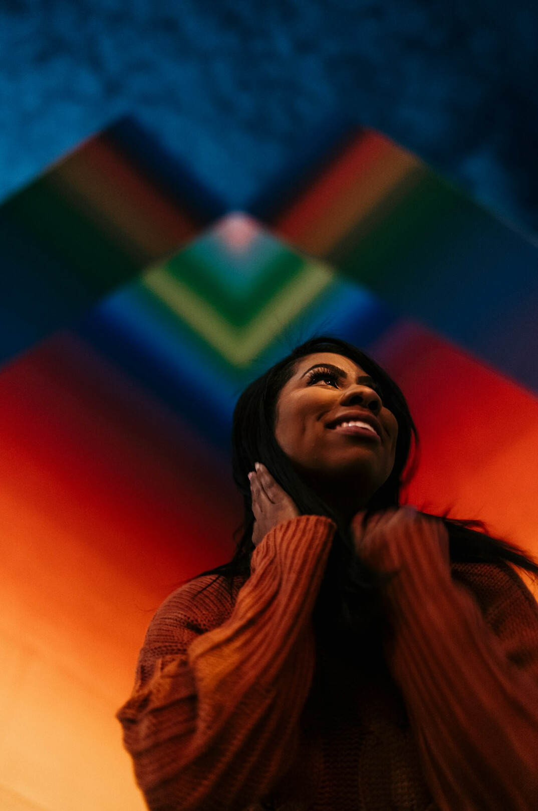 Studio portrait of a smiling woman with dark hair on a colorful background