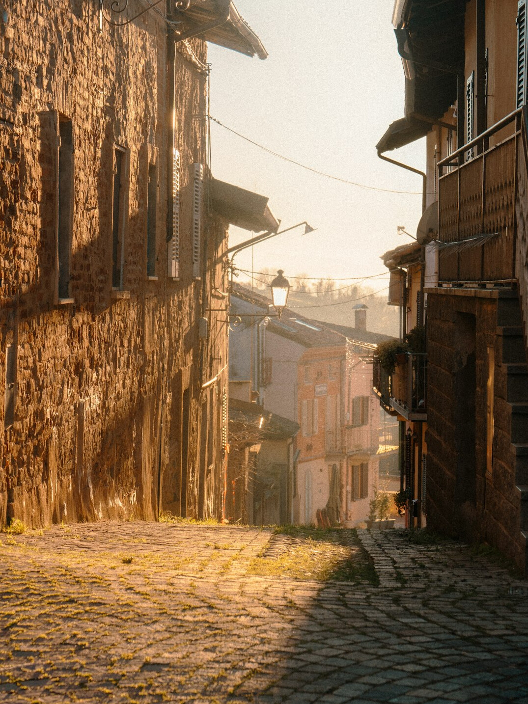Narrow old town street with historic facades at dawn