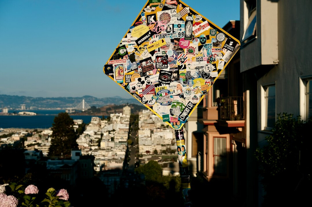 Corkboard with photographs and notes connected by thread