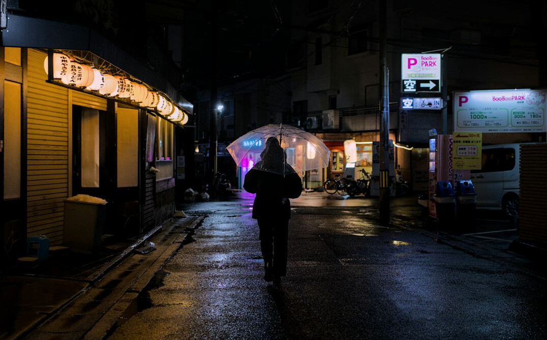 woman walking alone on street at dusk
