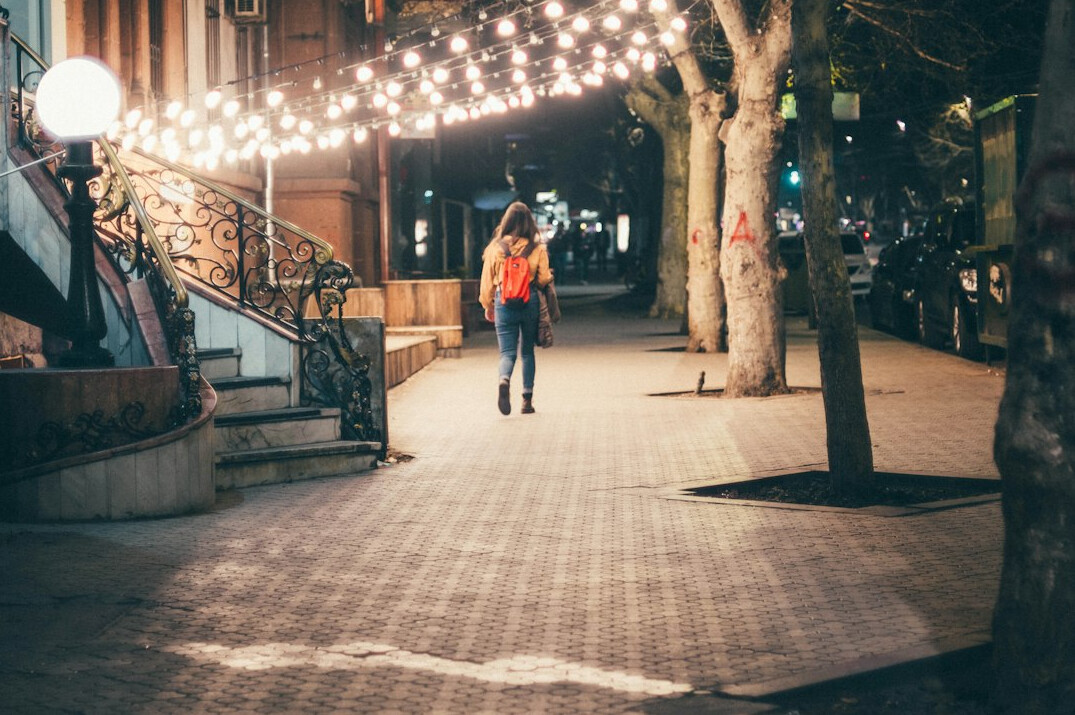 woman walking alone on street at dusk