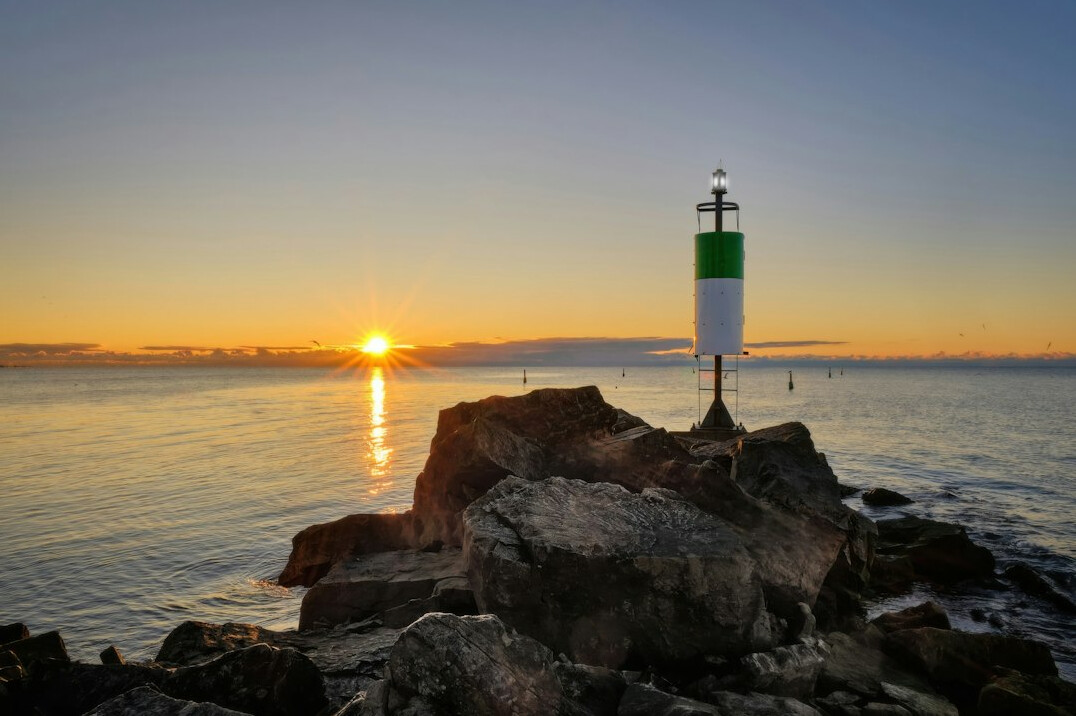 Lighthouse on a rocky coast at sunset